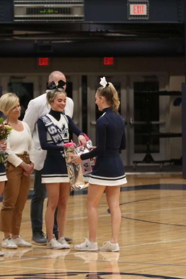 Receiving her gift from freshman Bella McPeake, senior Lucy Pearce is recognized as a cheer senior.