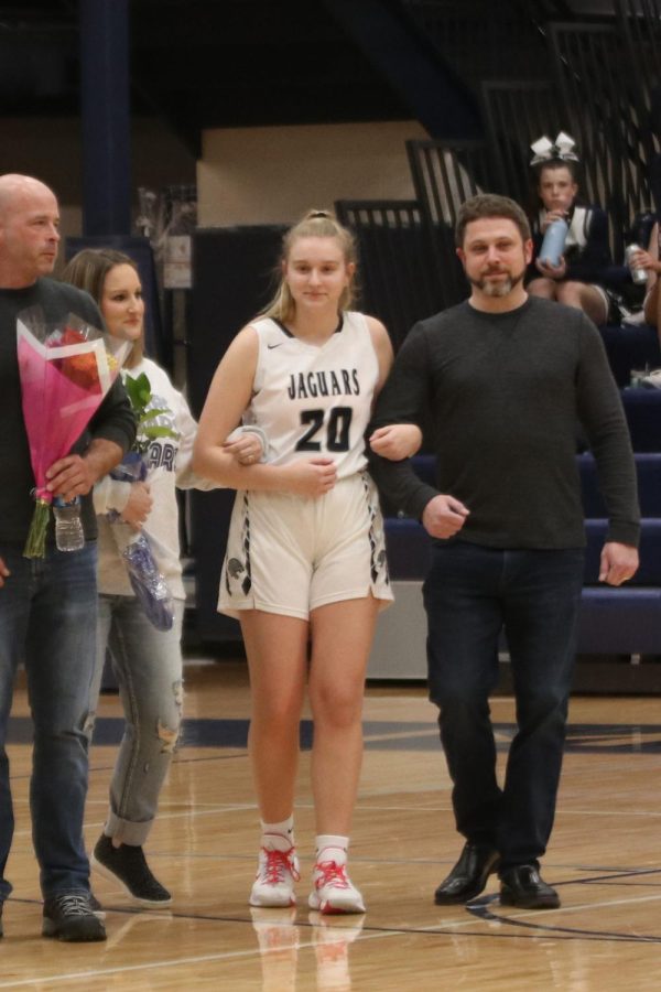 In between her parents, basketball senior Ryleigh Kennedy is recognized.