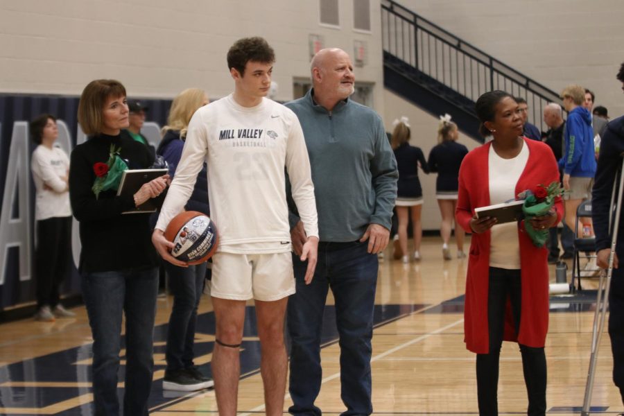 With his senior gift in hand, basketball senior Ryan Cummings stands alongside his parents.