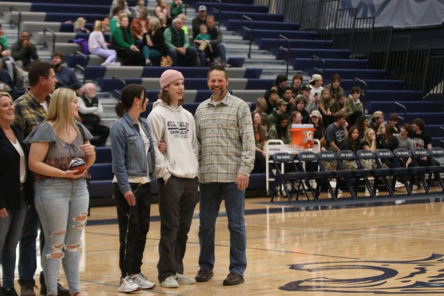 Being recognized, senior Adam Budmlija smiles with his parents.