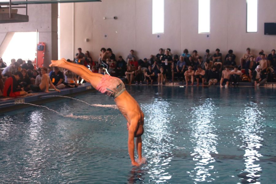 Completing his dive, junior Max Roh enters the water.