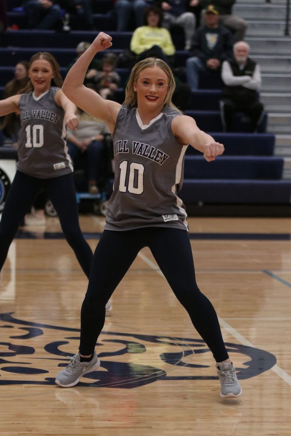 Fist in the air, junior Trinity Baker dances with the Silver Stars during halftime. 