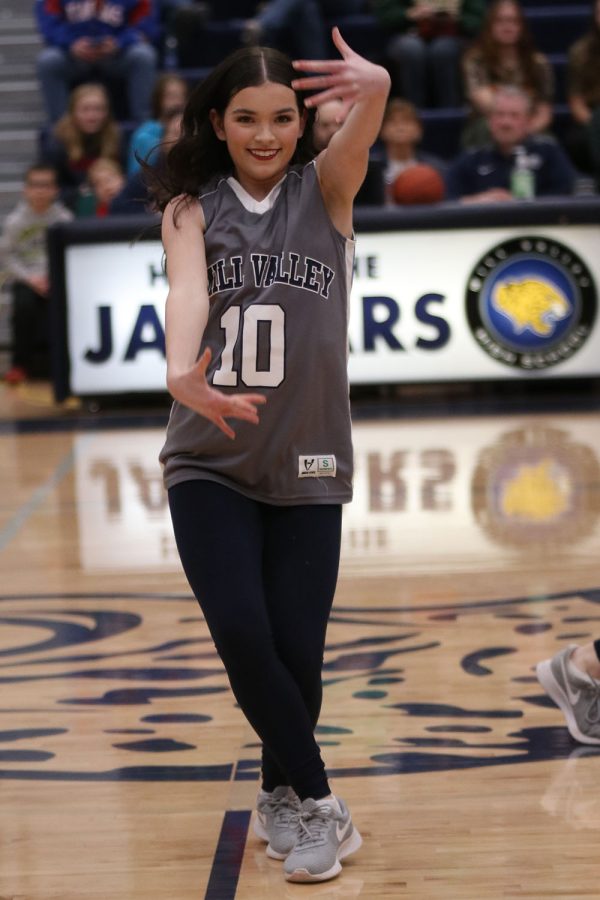 Hands raised, junior Keira Bret dances during halftime with the Silver Stars. 