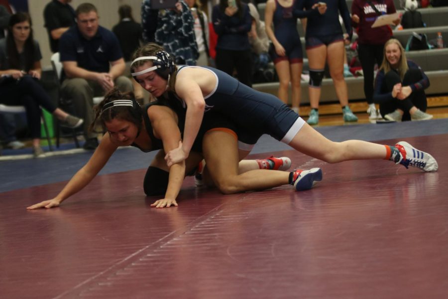 Determined to pin her opponent, sophomore Piper Wendler reaches for her opponents arm.