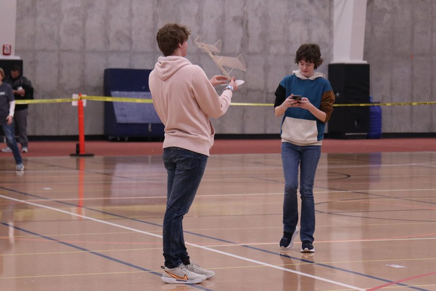 Winding the propeller on the front of their recently repaired plane, sophomore Carter Tollman and senior Sydney Downey prepare for a test flight.