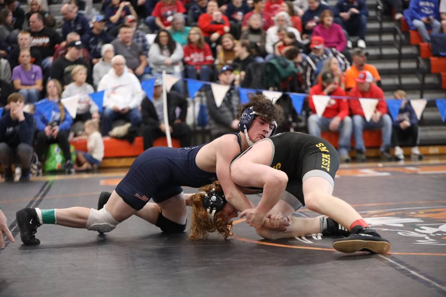 With his opponent underneath him, junior Maddox Casella tries to pin him. 