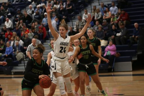 Jumping in the air, sophomore Averie Landon blocks the opponent.