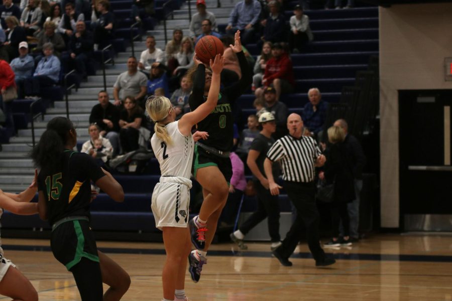 Attempting to block the ball, junior Keira Franken puts her arms in the air.