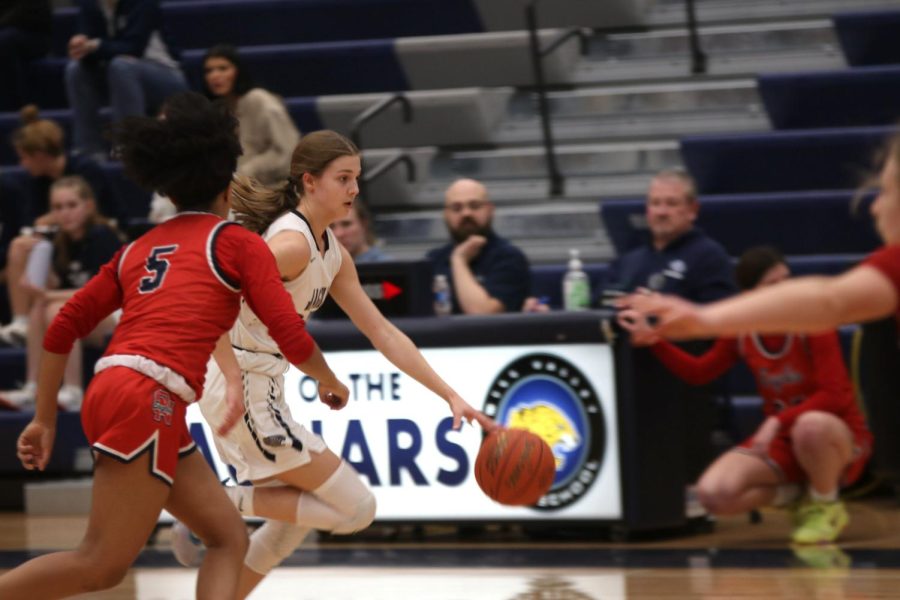 Dribbling through Olathe North players, sophomore Averie Landon moves down the court.
