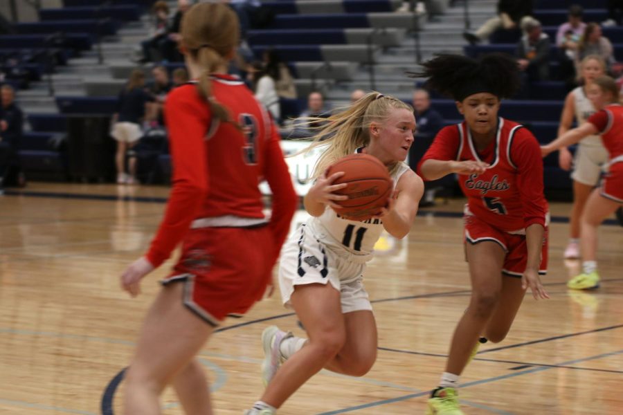 Avoiding Olathe North players, senior Sophie Pringle goes toward the hoop.
