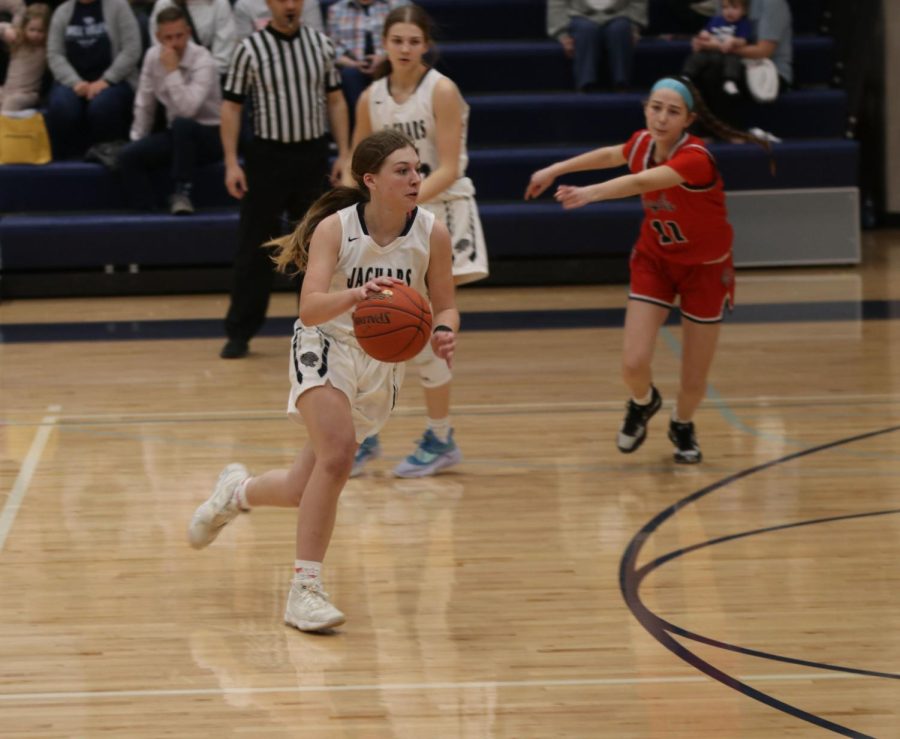 Looking for an open teammate, sophomore Gracie Kurzejeski runs down the court.
