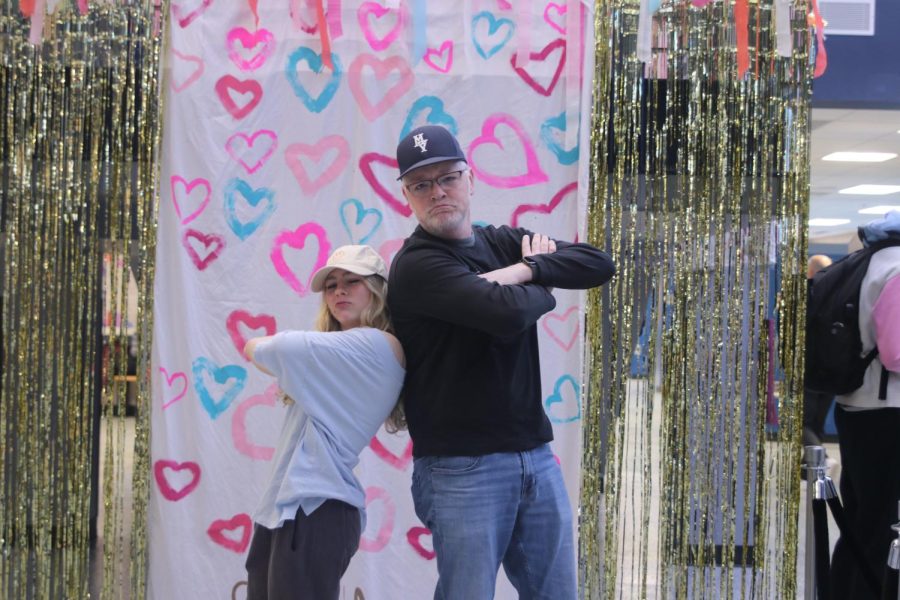 Backs together, junior Violet Hentges and science teacher Chad Brown pose for a picture.