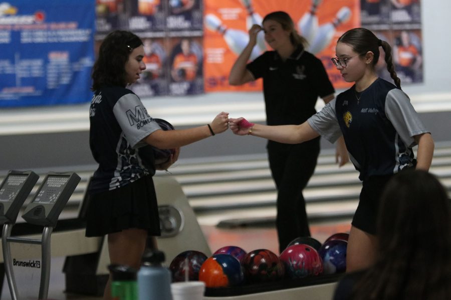 Senior Eden Hakes and sophomore Miranda Hakes give each other an encouraging fist bump after a frame. 