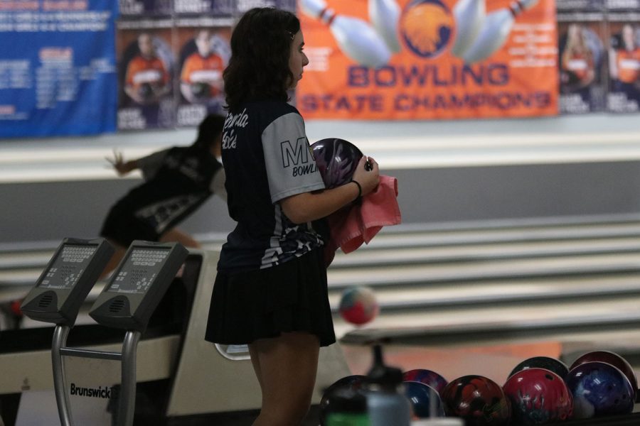 Getting ready for the next frame, sophomore Miranda Hakes wipes the lane grease off her ball. 