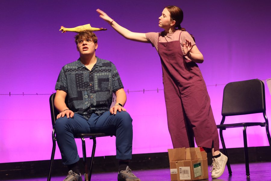 Sophomore Reese Miller performs the bit of placing a rubber chicken on junior Blake Powers’s head. 
