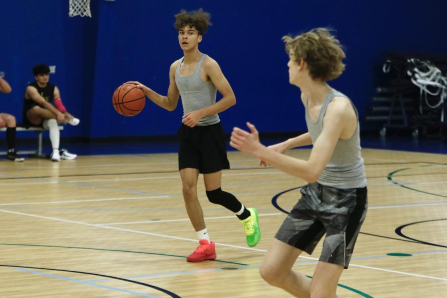 Moving down the court, junior Jordan Harrison locks to pass the ball to teammate junior Noah Brueggemann at their game Tuesday, Jan. 24.