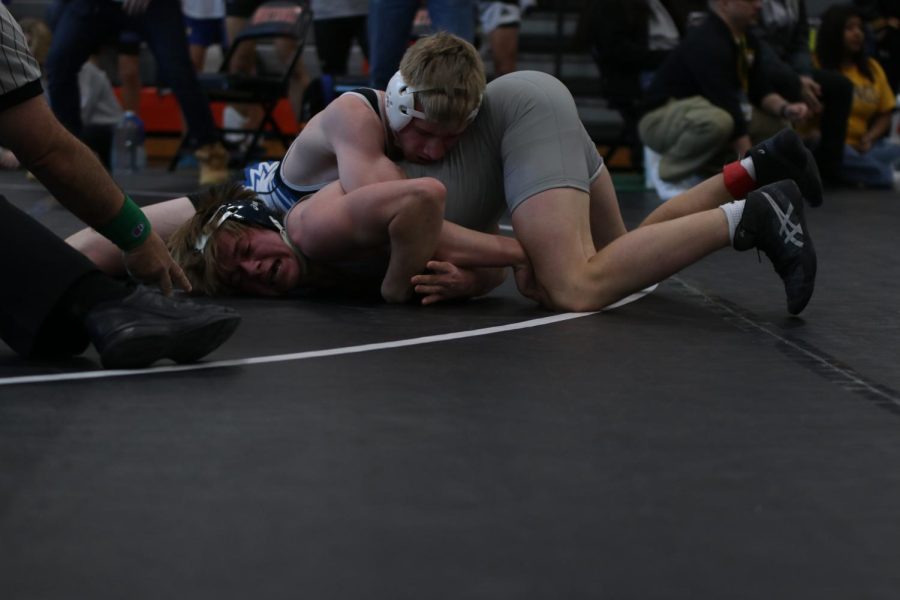 While being pinned down by his opponent, junior Haden Applebee attempts to break free.