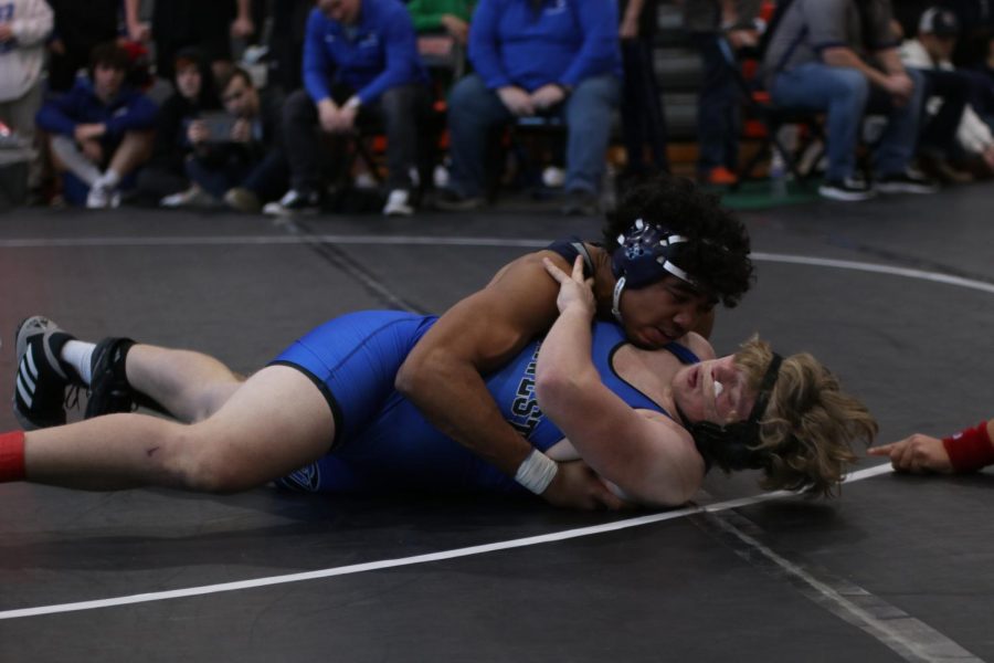 Focused, sophomore Jayden Woods pins his opponent to the floor.