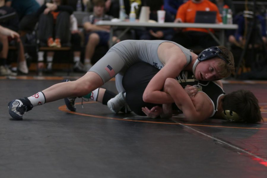 On top of his opponent, freshman Jeredy Nilges wraps his arms around his opponent in an attempt to pin him down.