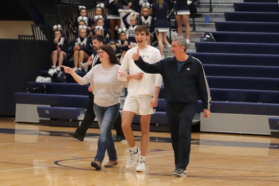 Smile on his face, senior Marko Skavo walks with his parents to the lineup of seniors. 