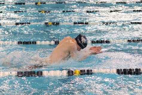 Head tucked, senior Adam Budimlija prepares to reach forward.