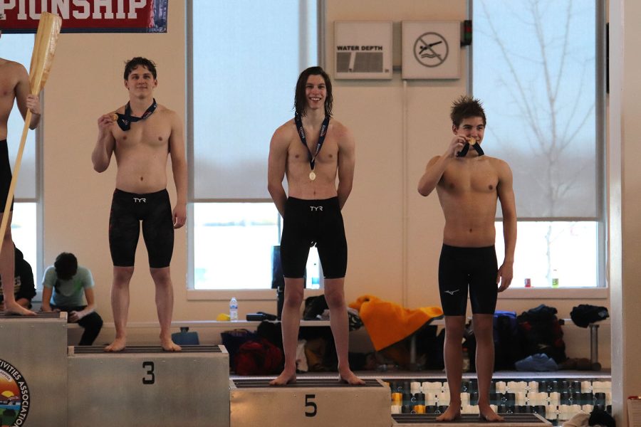 Senior Adam Budimlija smiles as he stands atop the podium.