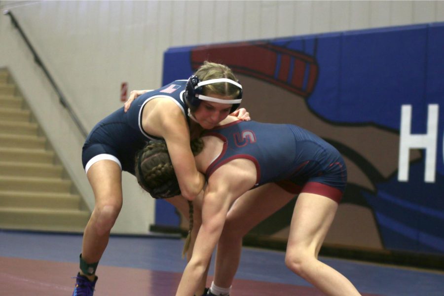 Holding onto her opponent, junior Emily Summa tries to take them down. 