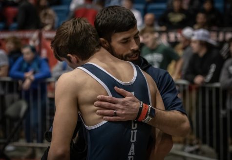 After his losing his last state match, boys wrestling head coach Joseph Lazor hugs senior Eddie Hughart.