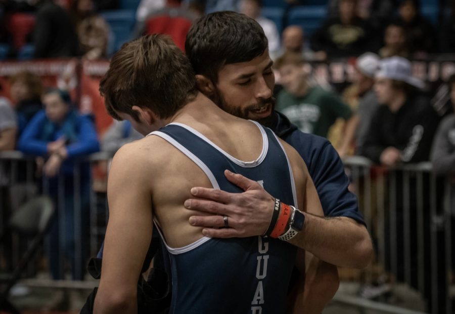 After his losing his last state match, boys wrestling head coach Joseph Lazor hugs senior Eddie Hughart.