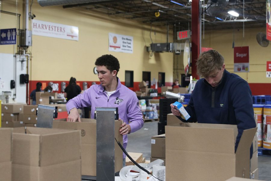 In the Harvesters main warehouse, JLC members seniors Hayden Jay and Luke Shideler sort baking items into boxes. 