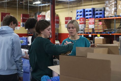 Sophomores Gracie Kurzejeski and Addison Long check to make sure that the items they place in the boxes have the labeling and the nutritional value. 