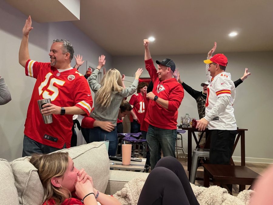 Hands raised, junior Peyton Zenger and her family's friends cheer for the Chiefs.