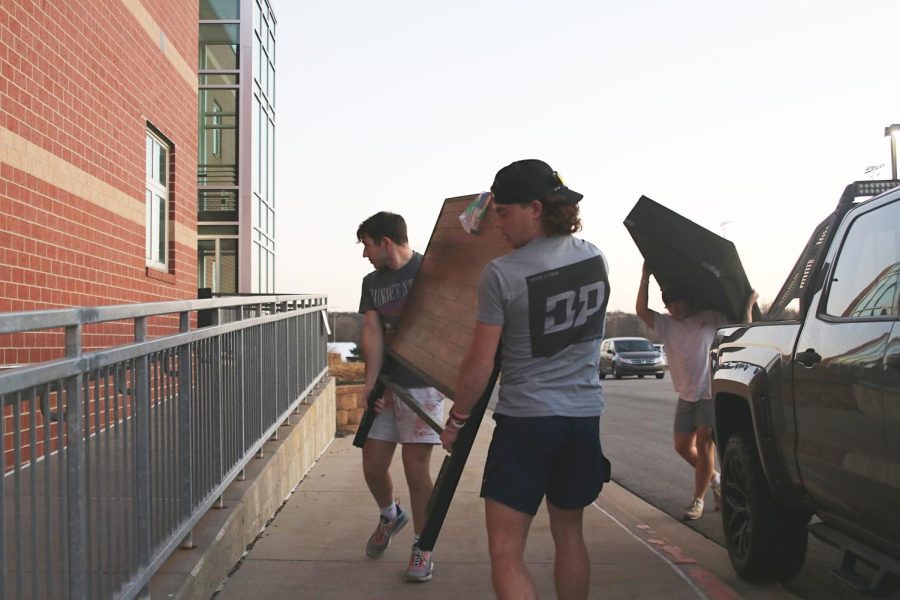 Members of the football team, juniors Gavin Johnson, Daniel Blaine and Ryan Deverill team up to unload a donated bed out of a truck for the House to Home project Tuesday, Feb 28.