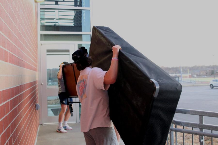 Junior Ryan Deverill carries a box spring, donated by junior Anna Zwahlen, up the access ramp, toward a lower B storage room.