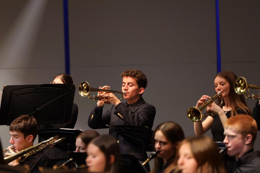 Looking down at his music, senior Charles Beal plays the trumpet.