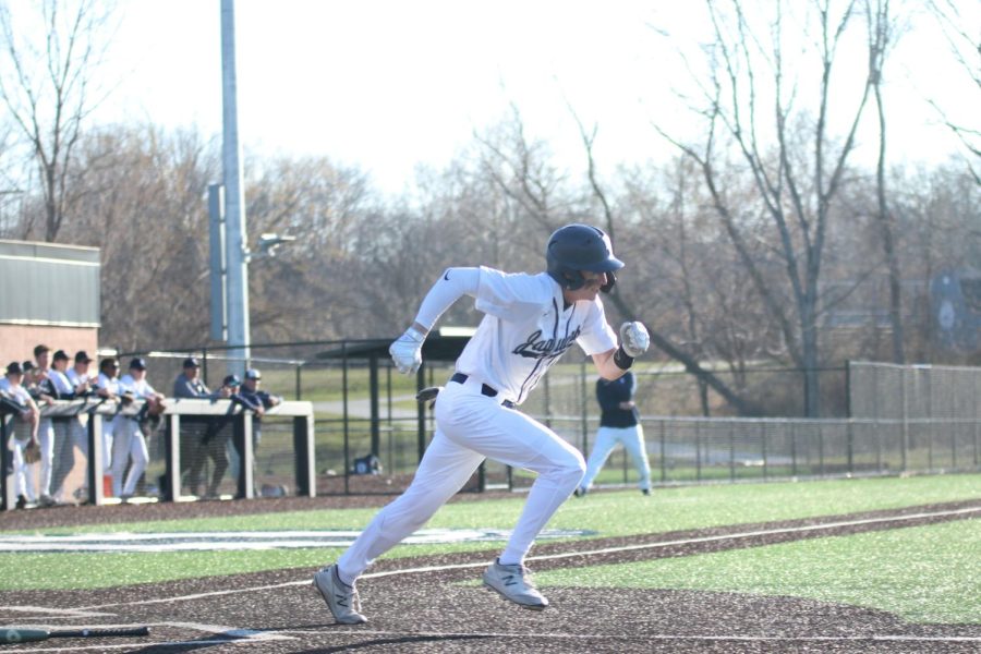 Looking towards first base, senior Matt Weis runs after having a successful bat.