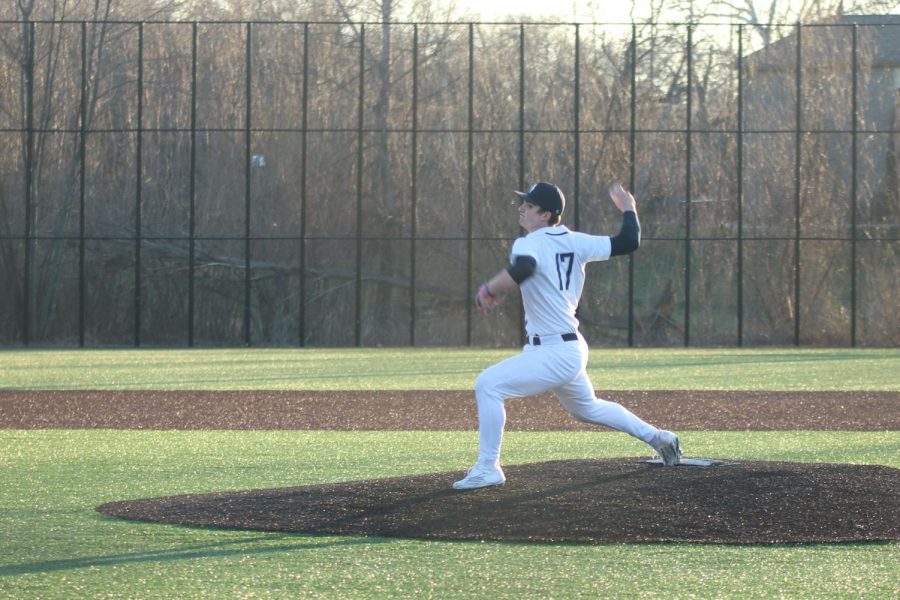 With his hand behind him, freshman Beau Peterson pitches the ball.