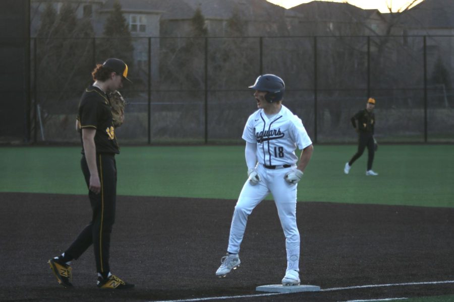 Standing on first base, junior Drew Snyder celebrates after successfully making it to the base safely.
