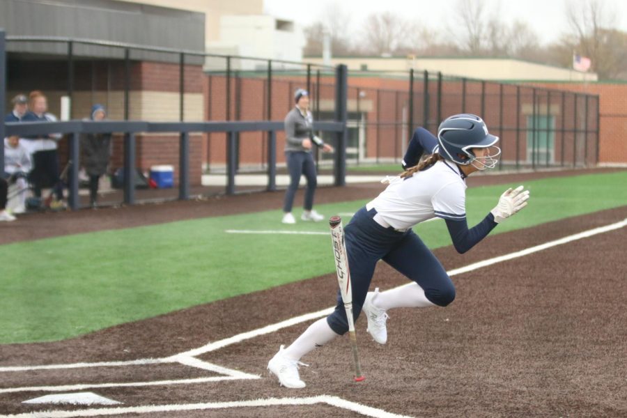 Dropping the bat, freshman Kinley Ruder runs to first base.