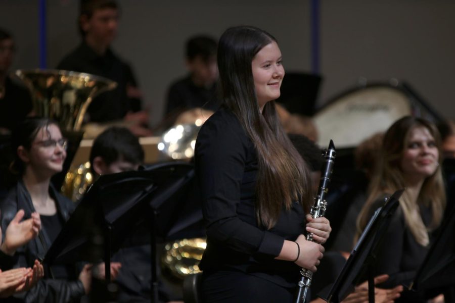 Freshman Jamie Boggs stands to be recognized for her help in designing the program for the band concert.