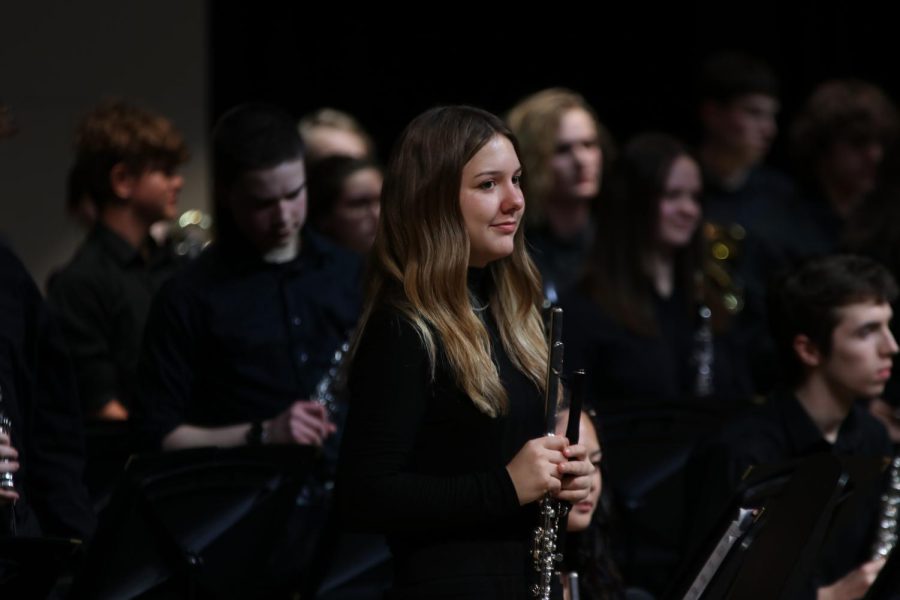 Smiling at the crowd, senior Sienna DelBorrell stands to be recognized for her solo in "Emperata Overture".