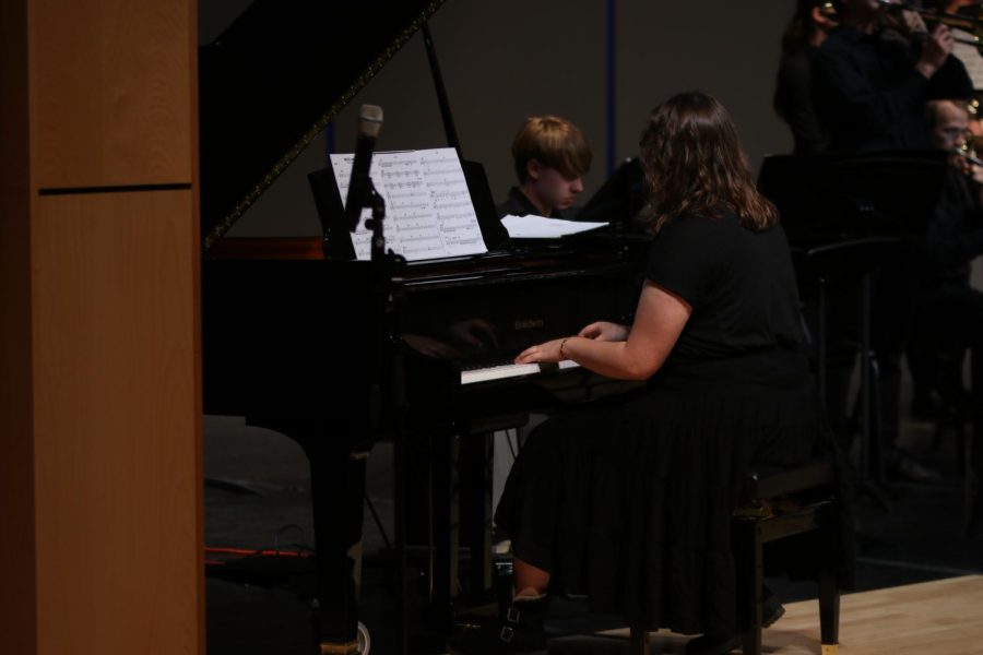 In the corner of the stage, senior Kate Hereth plays the piano for jazz band during their performance of Brass Machine.