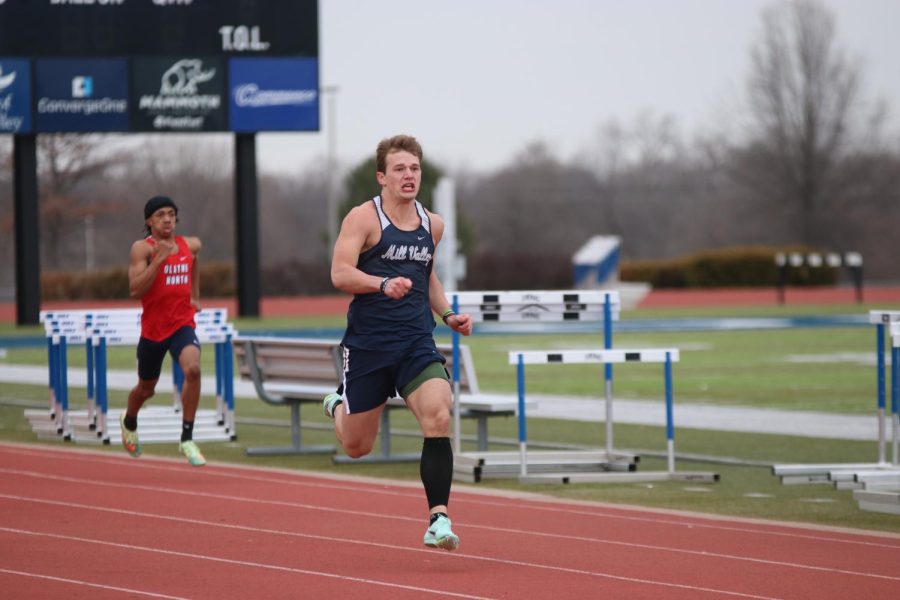 Striding towards the finish line in the 200 meter dash, senior Hayes Miller focuses on finishing strong. Miller placed second with a time of 22.55 seconds.