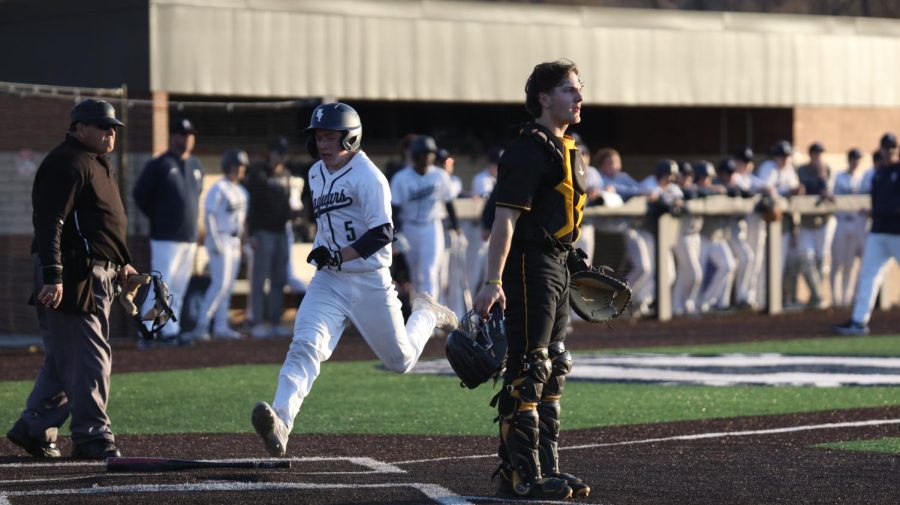Running hard, senior Brant Benson makes it to home plate safe. 