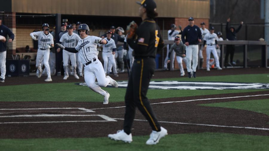Trying to beat the ball, freshman Beau Peterson gets ready to slide into home plate. 