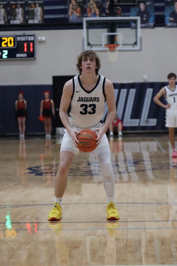 Standing on the free throw line, junior Mason Kemp gets ready to shoot for the extra point. 
