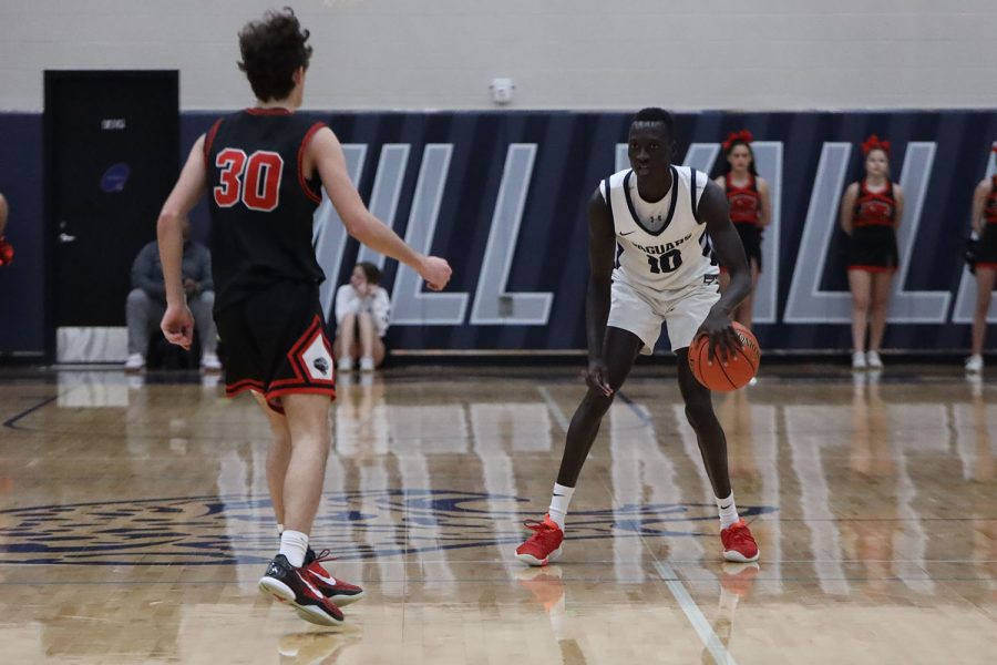 Dribbling down the court, senior Nen Matlock looks for an open teammate to pass to. 