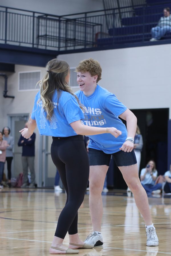 With his partner junior Halle Wampler, junior Garrett Cronin dances in front of the school. 