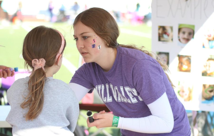 Sophomore Gracie Kurzejeski paints a girls face at her face painting booth.