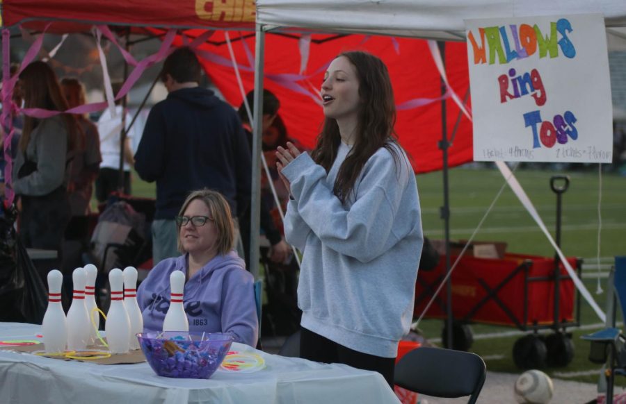 Senior Analia Stevens cheers on a participant at her ring toss booth.